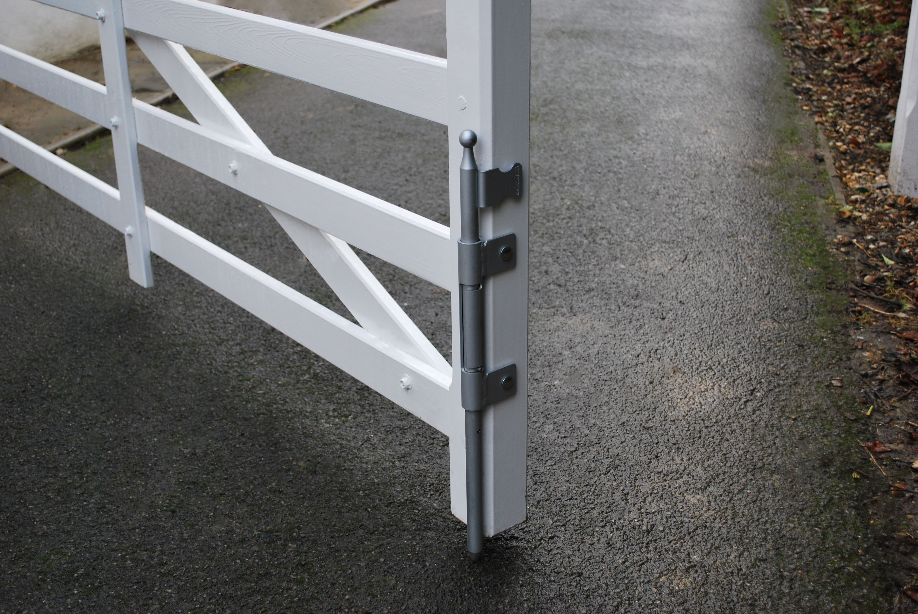 Verrouillage automatique à pêne basculant en applique sur un portail en bois blanc