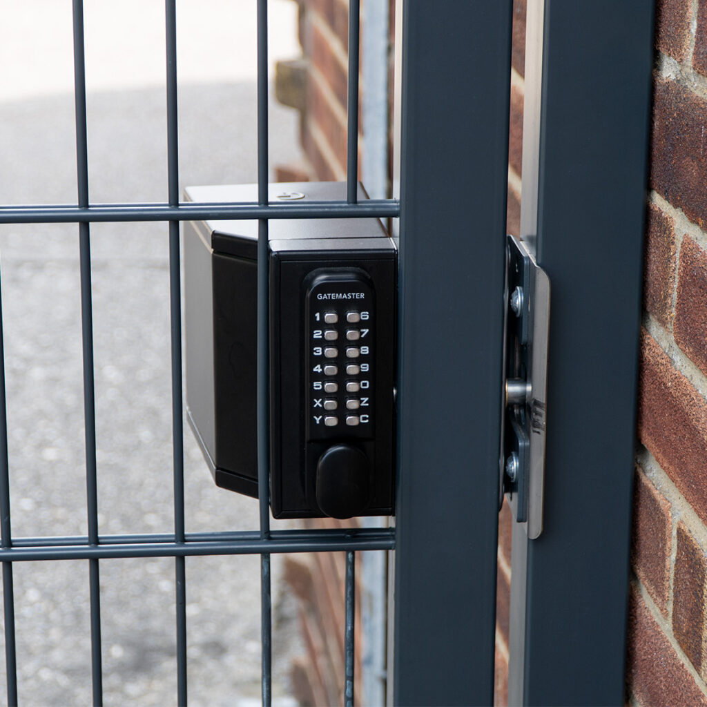metal gate and brick post. Bolt on metal gate lock installed in mesh fencing on football entrance
