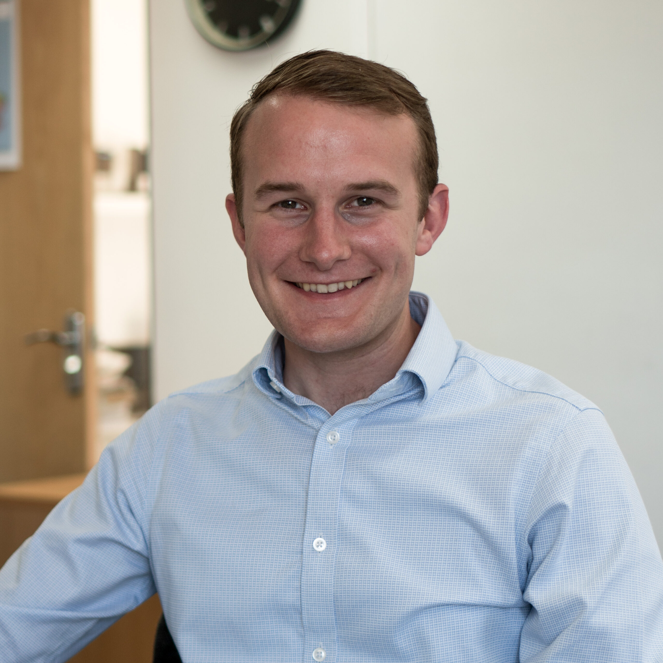 man in blue shirt looking into camera and smiling