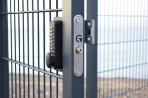 Image showing metal gate lock with mechanical keypad on an open mesh gate