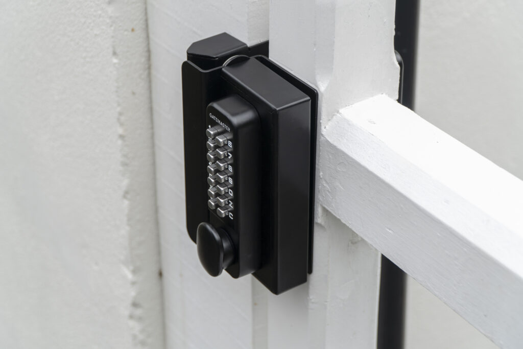 Surface fixed digital keypad lock on white timber gate