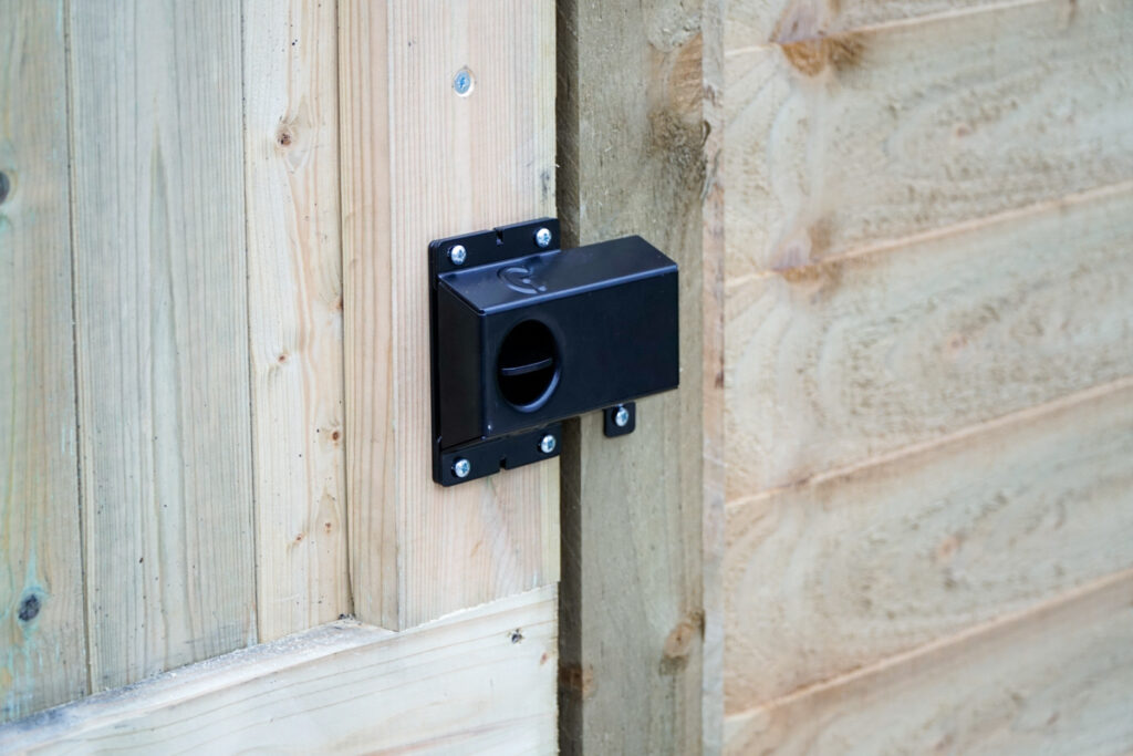 Light softwood garden gate with a latch handle and shroud installed.