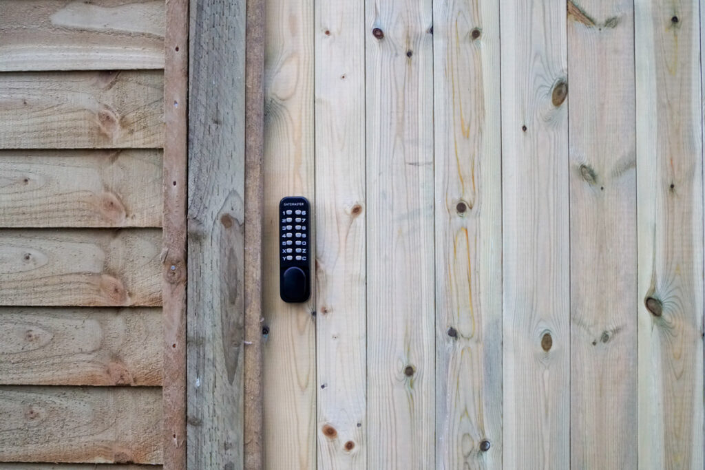 Portail et clôture en bois. Le portail est équipé d’une serrure mécanique à clavier