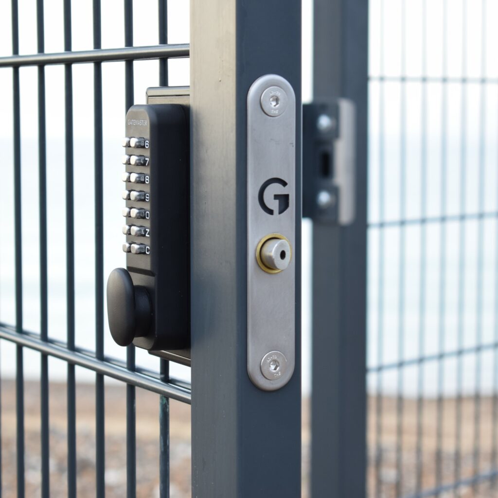 gate locks with code on grey metal mesh gate.