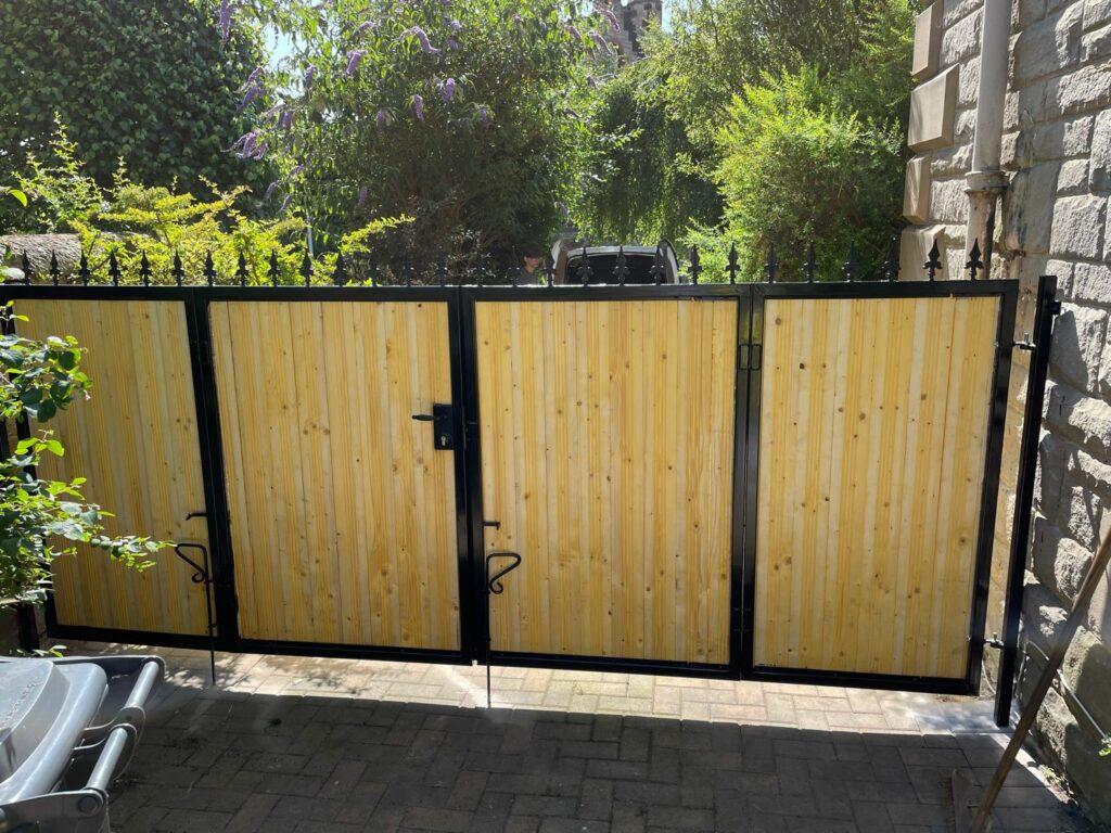 black bolt-on lock installed on light wood-style composite gate.