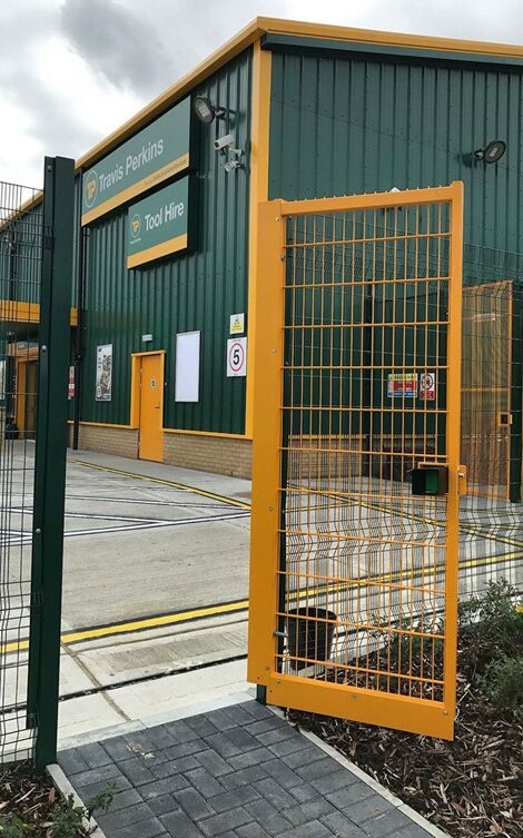 right handed yellow metal gate in front of green building