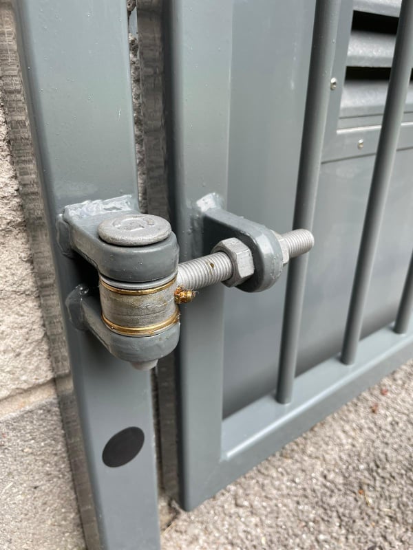 heavy duty industrial gate hinge on grey metal gate