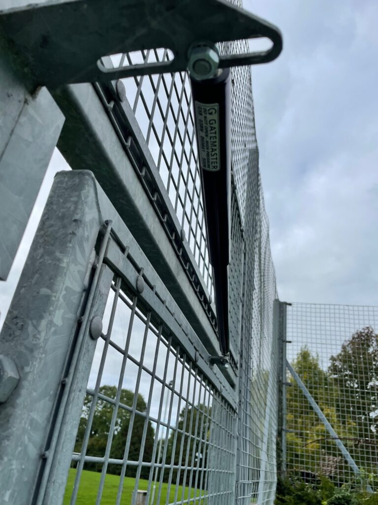 Gate closer installed on tennis club entrance gates