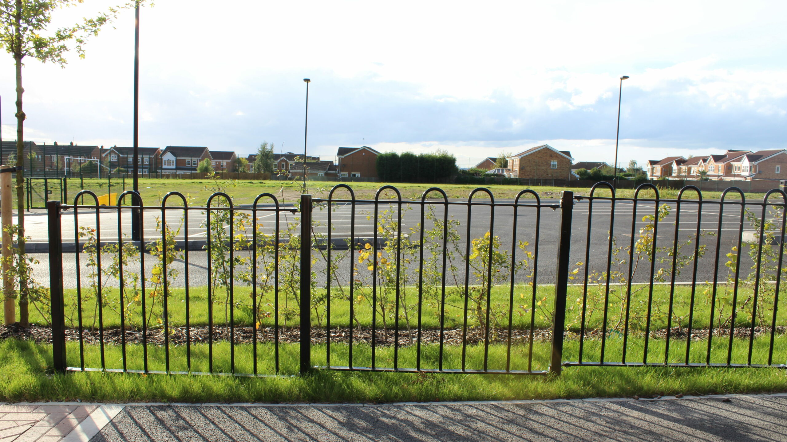 Bow top railings installed in front of school parking spaces.