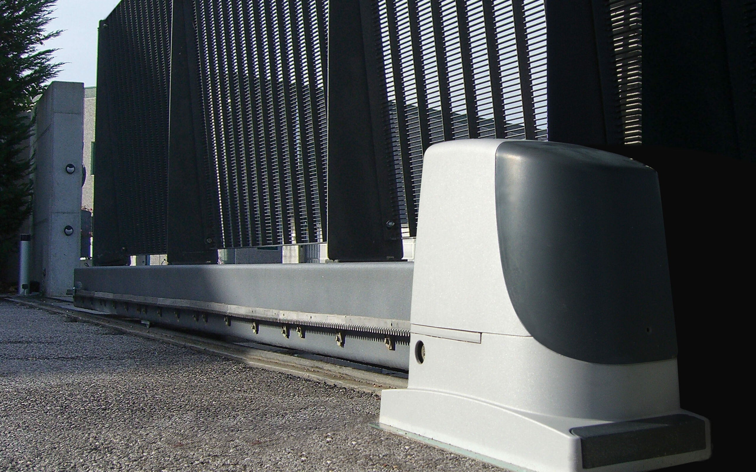 Low view of an automated electric gate system installed on large mesh gate.