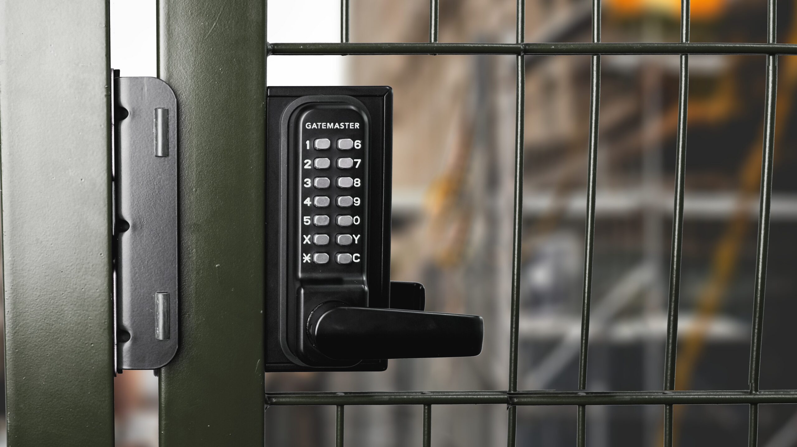 Double sided gate lock with digital keypad on both sides on a green gate fence
